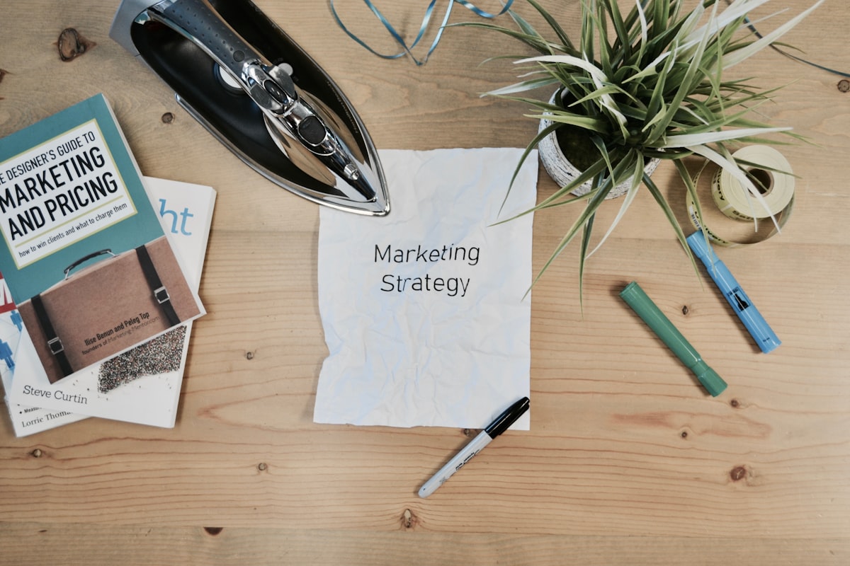 1080x600 Notebook with the words Marketing Strategy beside pens