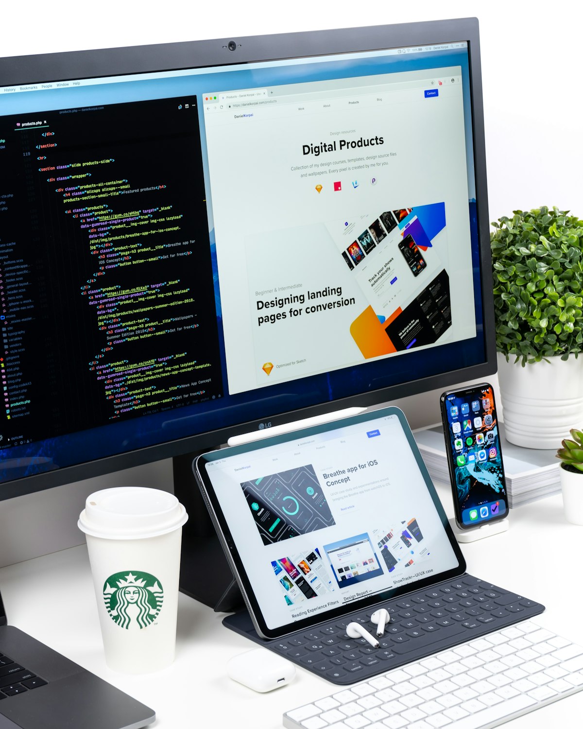 Landing page design shown on a monitor beside code
